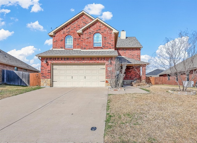 traditional home featuring a garage, brick siding, fence, and driveway