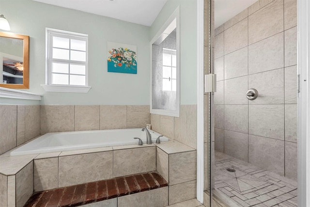 bathroom with a garden tub and tiled shower