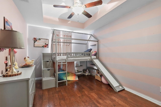 bedroom featuring a ceiling fan, a raised ceiling, and wood finished floors