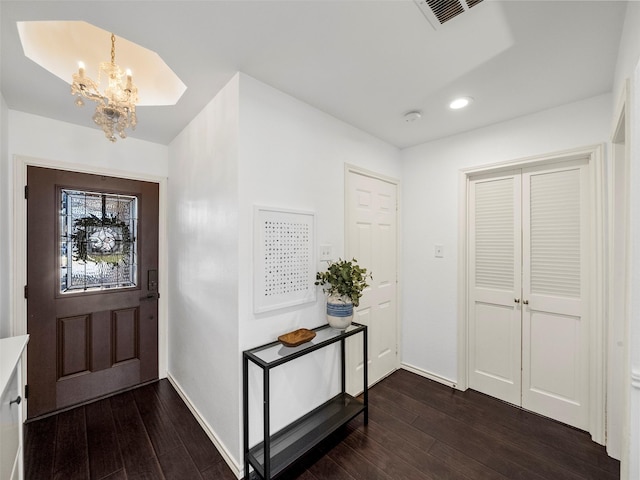 entrance foyer featuring recessed lighting, dark wood-style flooring, visible vents, baseboards, and an inviting chandelier