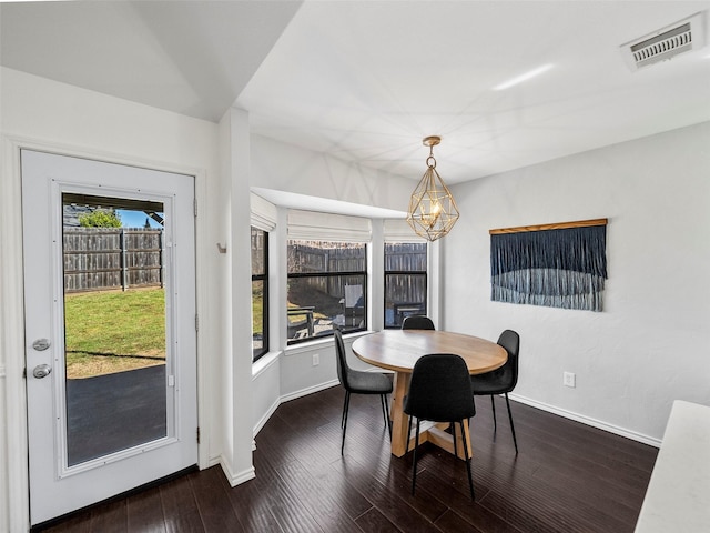 dining space featuring dark wood-type flooring, visible vents, and baseboards