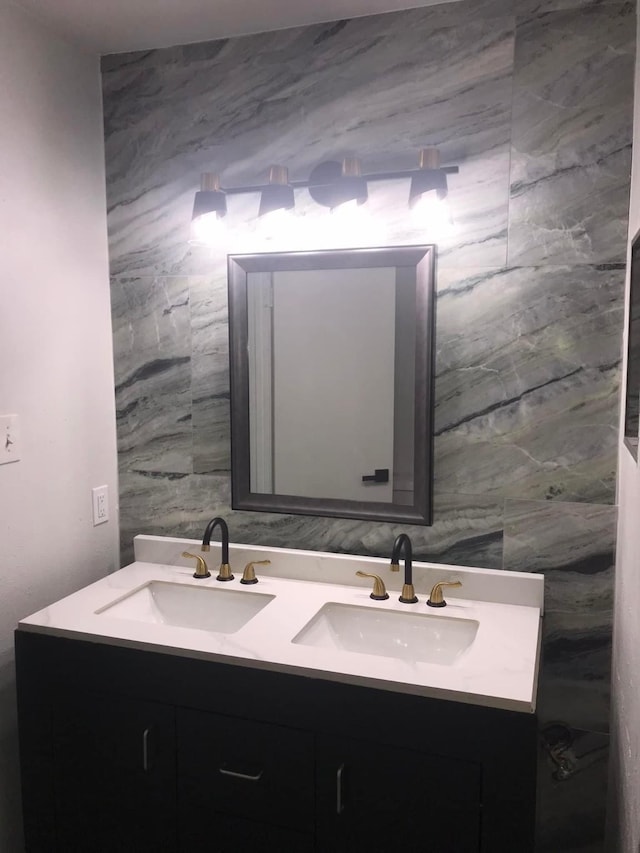 full bathroom with double vanity and a sink