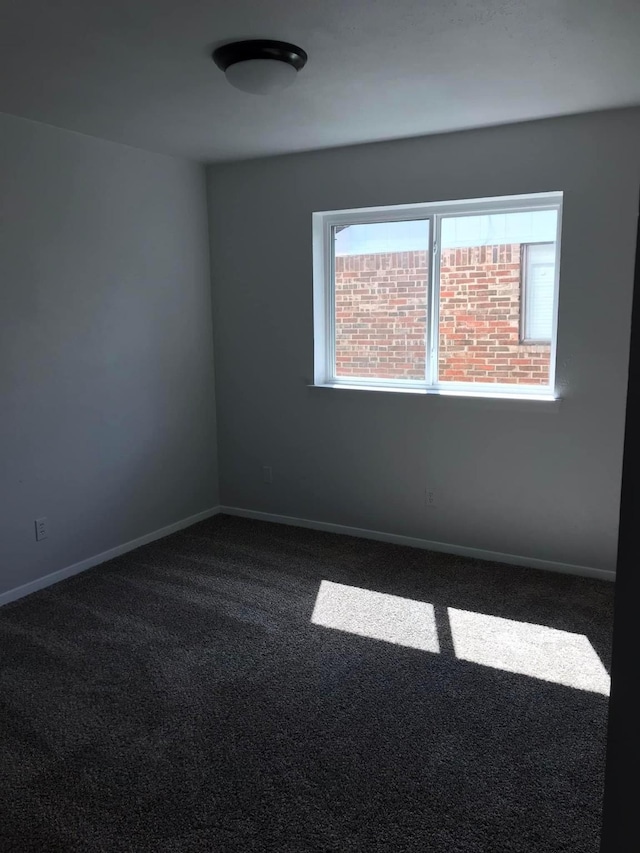 spare room with carpet and baseboards