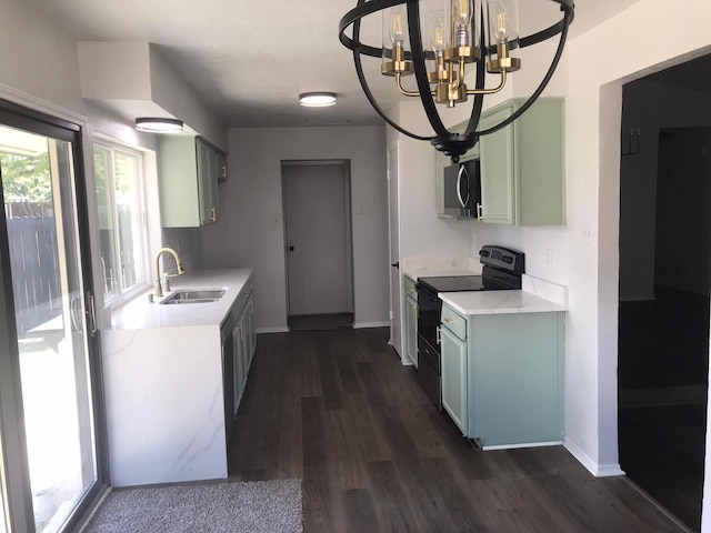 kitchen with black range with electric stovetop, a sink, light countertops, dark wood-style floors, and stainless steel microwave