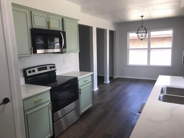 kitchen with dark wood-style floors, pendant lighting, stainless steel appliances, green cabinetry, and baseboards