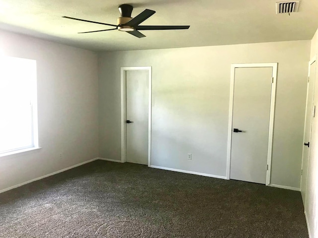 unfurnished bedroom with a ceiling fan, carpet flooring, visible vents, and baseboards