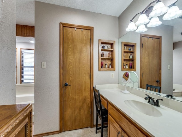 full bathroom with a bath, a textured wall, a textured ceiling, and vanity