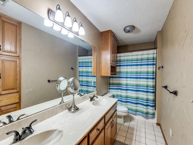 bathroom featuring a textured ceiling, tile patterned flooring, a sink, and toilet