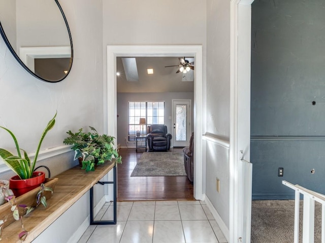 hall featuring baseboards and light tile patterned floors