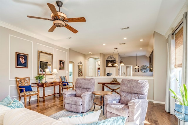 living area featuring visible vents, arched walkways, wood finished floors, and recessed lighting