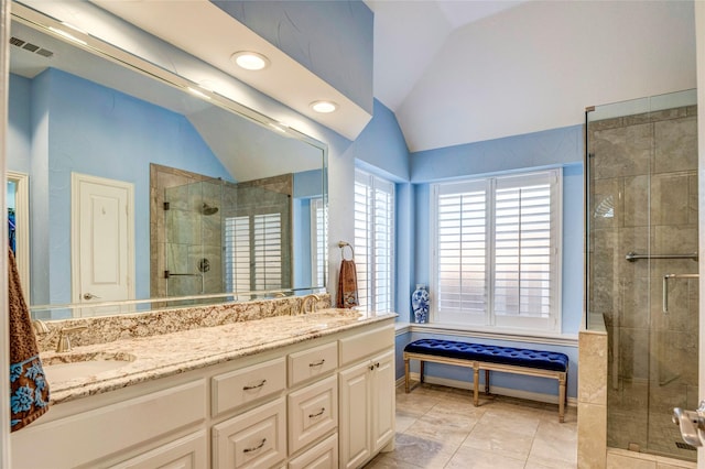 full bathroom featuring double vanity, visible vents, lofted ceiling, a shower stall, and a sink