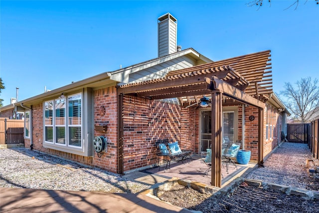 rear view of house featuring a fenced backyard, brick siding, a pergola, a chimney, and a patio area