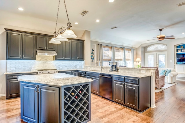 kitchen with visible vents, a kitchen island, a sink, under cabinet range hood, and dishwashing machine