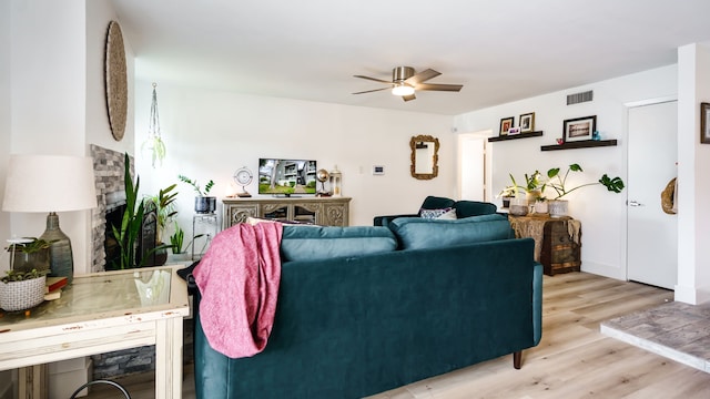 living area featuring ceiling fan, visible vents, and light wood-style floors