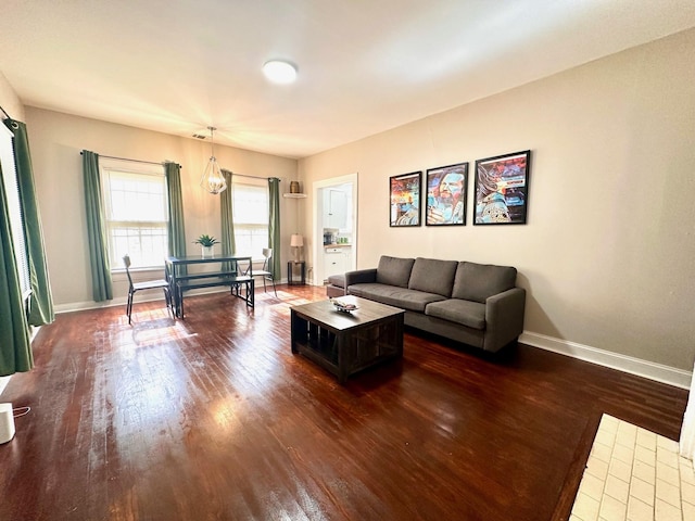 living room featuring dark wood-style flooring and baseboards