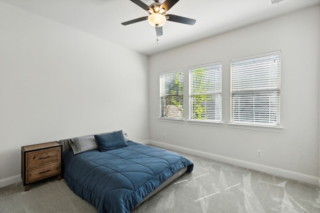 bedroom with light carpet, ceiling fan, and baseboards