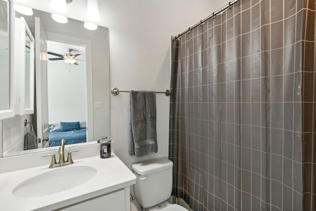 ensuite bathroom featuring connected bathroom, toilet, vanity, a ceiling fan, and a shower with curtain