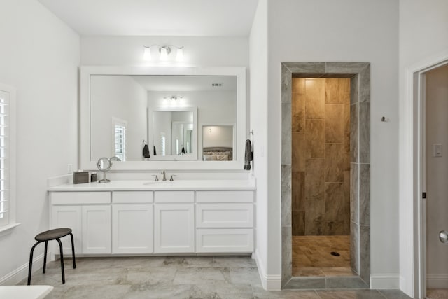 full bathroom featuring visible vents, walk in shower, vanity, and baseboards