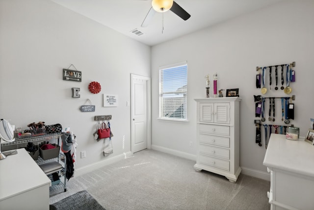 office with baseboards, visible vents, ceiling fan, and light colored carpet