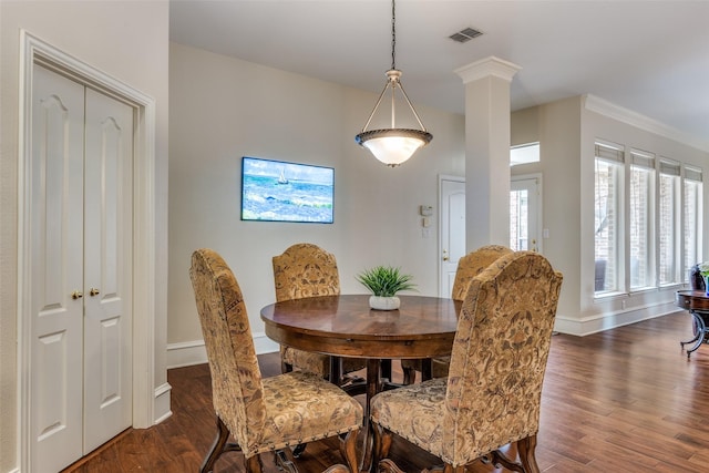 dining area with dark wood-style floors, baseboards, visible vents, and ornate columns