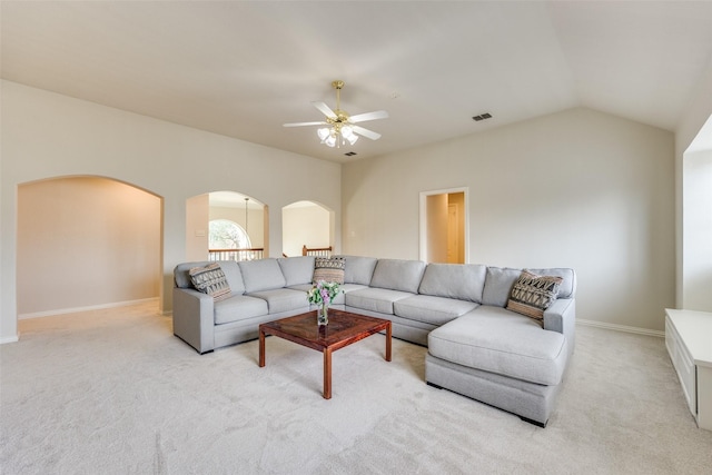 living room with light carpet, visible vents, vaulted ceiling, and arched walkways