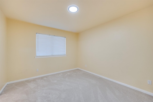 carpeted empty room featuring baseboards