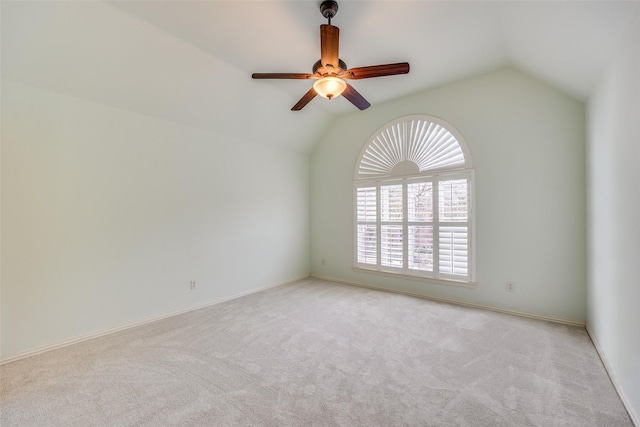 spare room with lofted ceiling, ceiling fan, baseboards, and light colored carpet