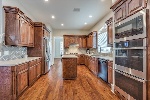 kitchen featuring dark wood-style floors, visible vents, appliances with stainless steel finishes, a sink, and a kitchen island