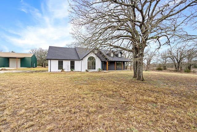 view of front of home with a front yard, an outdoor structure, and an outbuilding