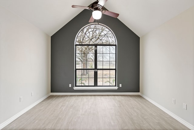 spare room featuring lofted ceiling, ceiling fan, baseboards, and wood finished floors