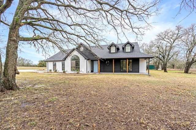 view of front of property with a shingled roof and a front yard