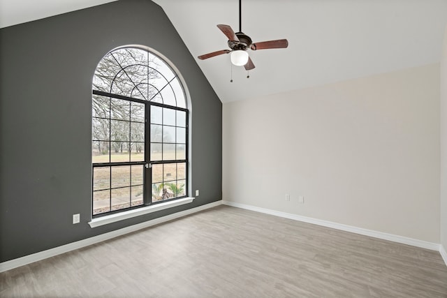 unfurnished room featuring a healthy amount of sunlight, high vaulted ceiling, and wood finished floors