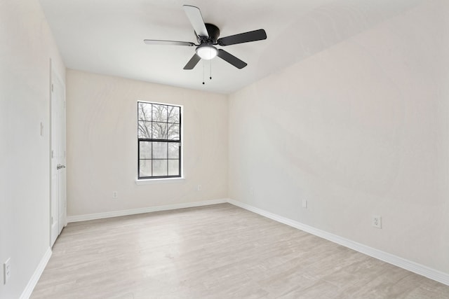 spare room with baseboards, ceiling fan, and light wood-style floors