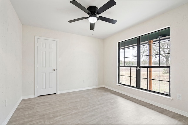 spare room with ceiling fan, baseboards, and wood finished floors