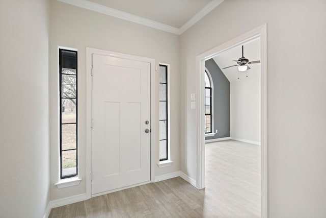 entryway featuring ornamental molding, baseboards, and light wood finished floors