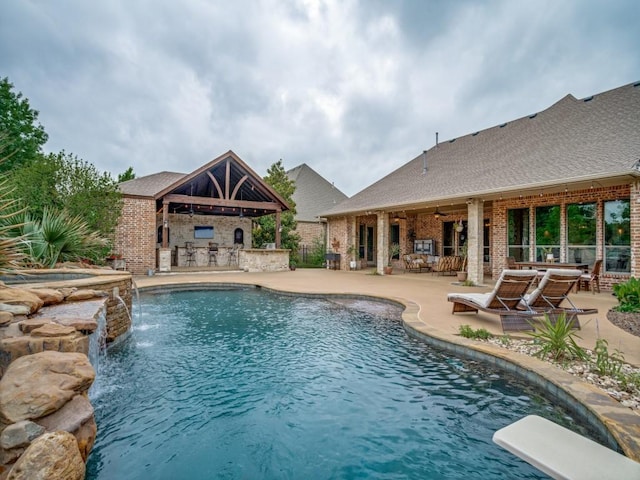 outdoor pool featuring a patio area, fence, outdoor dry bar, and a gazebo