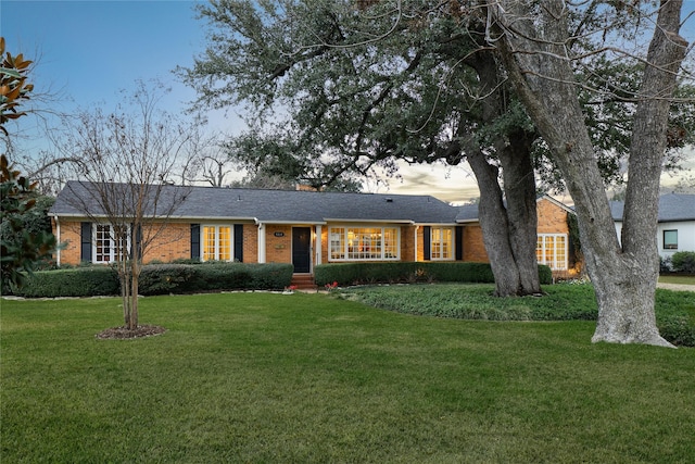 single story home featuring brick siding and a front yard