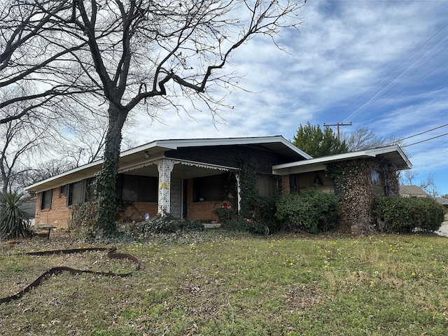 view of front of home with brick siding and a front yard