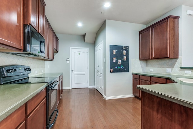 kitchen featuring black appliances, tasteful backsplash, dark wood finished floors, and baseboards