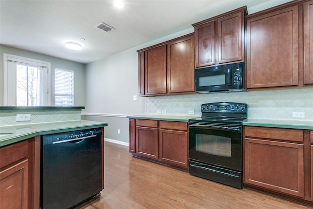 kitchen featuring light wood-type flooring, visible vents, backsplash, and black appliances