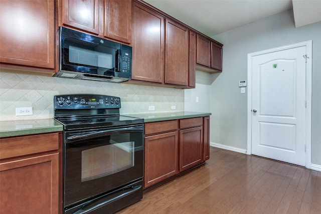 kitchen with dark wood-style floors, baseboards, decorative backsplash, and black appliances