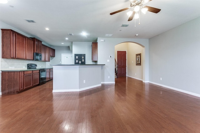 kitchen featuring black appliances, visible vents, arched walkways, and dark wood-type flooring