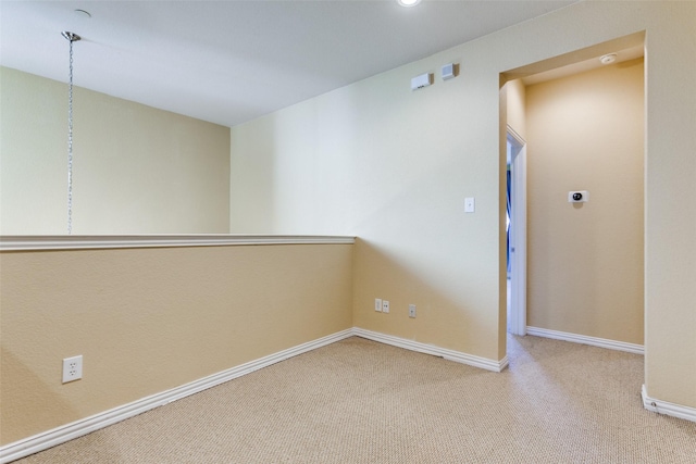 unfurnished room featuring carpet floors and baseboards