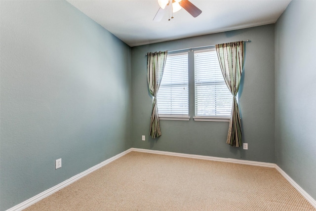 unfurnished room with a ceiling fan, carpet, and baseboards