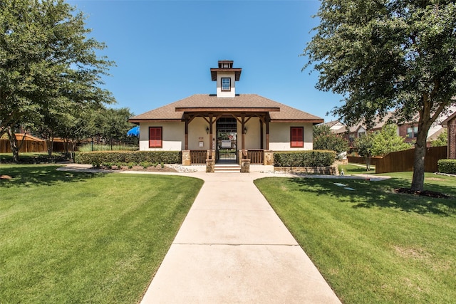 view of front of property with a front lawn, fence, and stucco siding