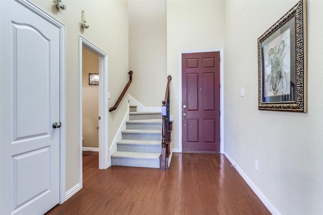 entryway featuring stairs, wood finished floors, and baseboards