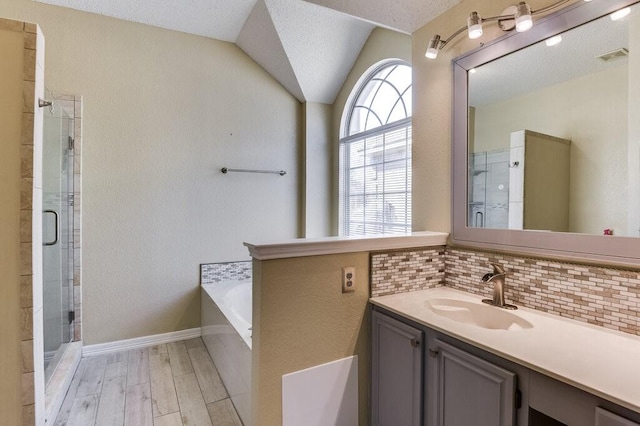 bathroom featuring wood finished floors, vanity, visible vents, a shower stall, and decorative backsplash