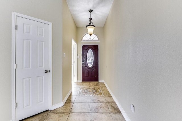 doorway to outside with light tile patterned flooring and baseboards