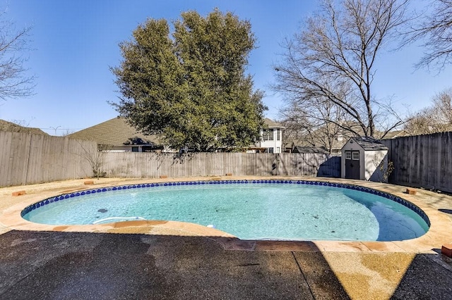 view of pool with a fenced in pool, a patio, a shed, a fenced backyard, and an outdoor structure