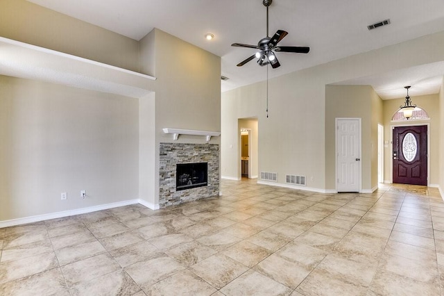 unfurnished living room with baseboards, visible vents, ceiling fan, and a fireplace